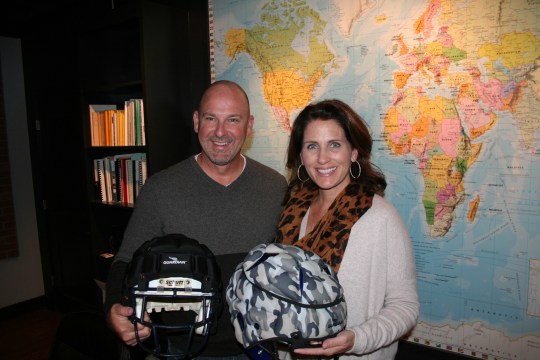 Lee and Erin Hanson hold helmets with Guardian Caps at their company's Alpharetta office.