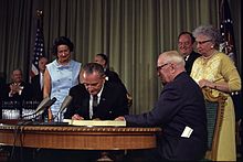 President Lyndon Johnson signing the Medicare law with former President Truman looking on. 