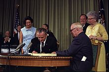 President Lyndon Johnson signing the Medicare law with former President Truman looking on.