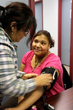 Gudelia Almazan, a social worker for Easter Seals North Georgia, checks Ismelda Santos' blood pressure.