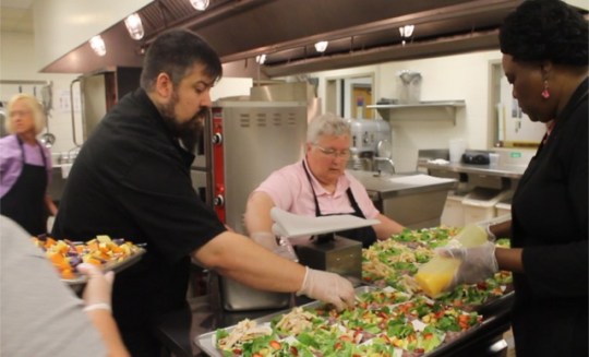 Chef Josh Aaron (far left) and Debbie Morris (far right) prepare the salad with food service manager Debra Patton.