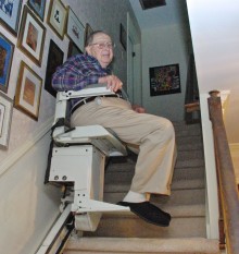 Retired Col. Irv Schoenberg heads to his home office — via an automatic stair lift.