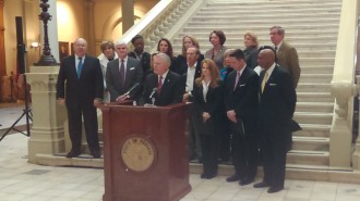 Gov. Nathan Deal addresses reporters Friday as members of the Child Welfare Reform Council look on.
