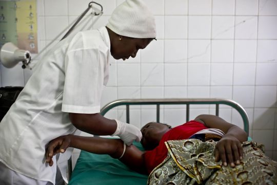 A nurse tends to a woman in a post-natal care unit at a hospital near Xai-Xai, Mozambique