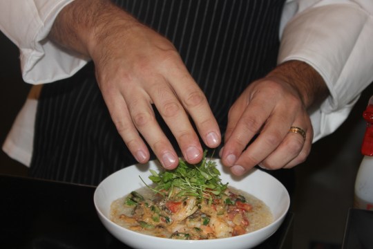 A Morrison Healthcare chef preparing shrimp and grits, which is featured at the Flavors 450 station (all entrees are 450 calories or less) as part of "Foodie Friday'' at Children's Healthcare of Atlanta at Scottish Rite.