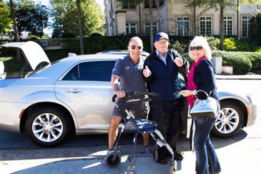 Bob and Anne Carr flank a military veteran as their company partnered with the Atlanta History Center to offer rides to veterans on Veterans Day.
