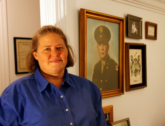 Carol Lively and a portrait of her grandfather during World War II