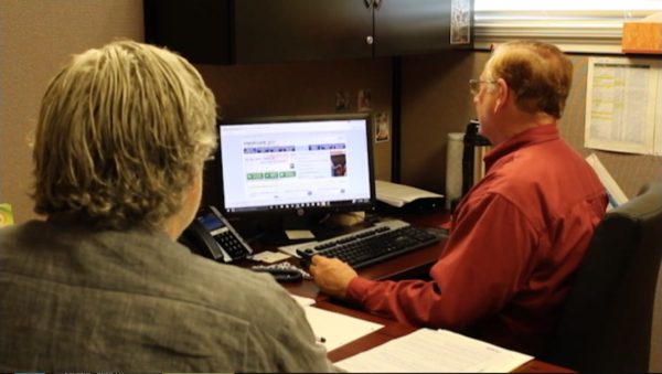 Navigator Harold Weber (at computer) helps a client.